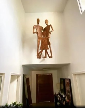 Logo acima da porta da entrada da mansão, Mirella e Ceará têm uma obra de arte que representa o casal com a filha