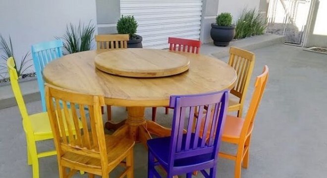 Modelo de mesa redonda com cadeiras de madeira coloridas