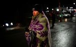 Protegido por um cobertor, rapaz chega caminhando à fronteira da Ucrânia com a Moldávia