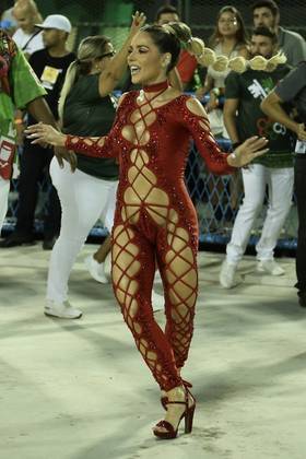 A atriz Monique Alfradique também usou um figurino vermelho e cheio de recortes, mas com a diferença de ser mais justinho no corpo. Ela foi um dos destaques da Grande Rio