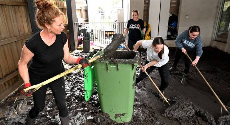 Moradores limpam casas em Melbourne após redução do nível das águas
