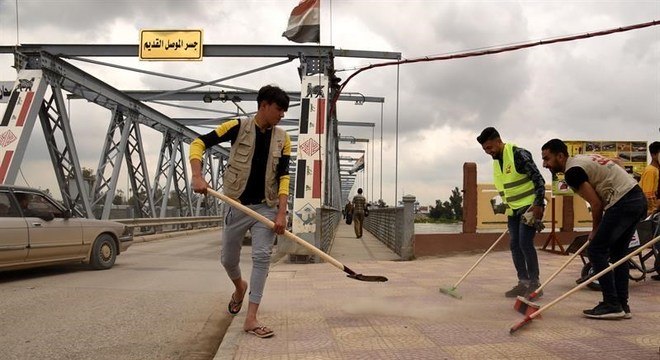 Moradores se unem para limpar as ruas da cidade de Mossul, no Iraque