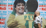 Torcedor passa ao lado de imagem de Pelé e Maradona, em São Paulo