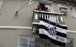 Torcedoras hasteiam a bandeira do Santos em casa próxima à Vila Belmiro