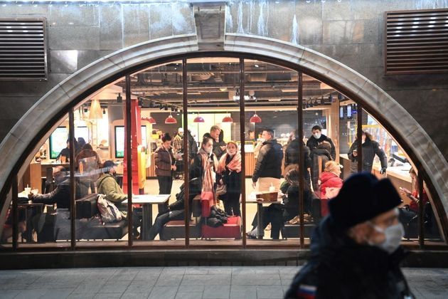 Pessoas em um café observam a movimentação da polícia, que fechou a praça Vermelha, em Moscou