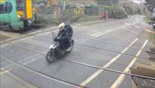 Motociclista imprudente escapa no último segundo de ser atingido por trem