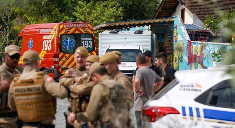 Policiais, equipes de resgate e familiares diante do centro de educação infantil, em Blumenau