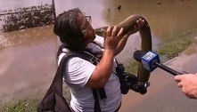 Mulher beija a boca de enguia encontrada nas águas de enchente