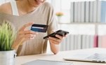 Mulher faz compra online no smartphone com cartão de crédito. Freepik/tirachardz
