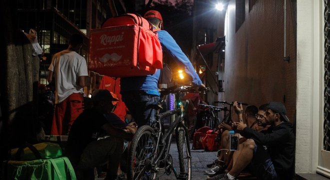 Na região da rua Augusta, centro de São Paulo, entregadores de aplicativos aguardam pedidos em calçada