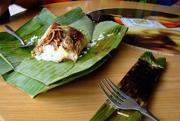Nasi Lemak: prato nacional da Malásia, o nasi é um arroz embalado em uma folha de bananeira e consumido como café da manhã. Os acompanhamentos podem ser frango, pepino, anchovas, amendoim e ovo. 