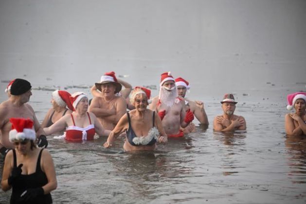 Members of the Berliner Seehunde (Berlin seals) swimming club take their traditional Christmas bath at the Oranke lake on December 25, 2022 in Berlin.
