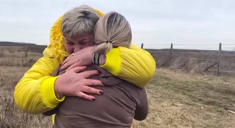 Nataliya, de jaqueta amarela, também se emocionou ao entregar as crianças para a mãe delas