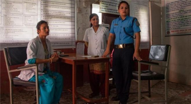 A equipe do centro de gerenciamento de crise - a enfermeira Punam Rawat, a conselheira Radha Paudel e a policial Sabita Thapa - assistem uma paciente