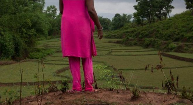 Neha, de 38 anos, espera do lado de fora de um abrigo para vítimas de violência doméstica