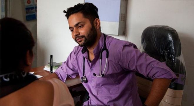 O médico Prabhat Rijal atende um paciente no ambulatório; ele regularmente identifica casos de violência doméstica e os encaminha para o centro de crise