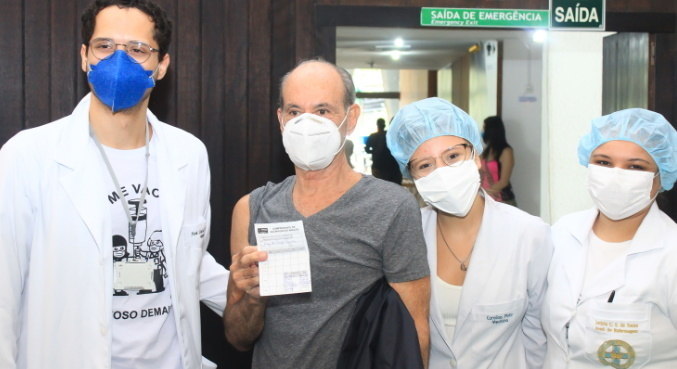 Ney Matogrosso com profissionais de saúde após ser vacinado