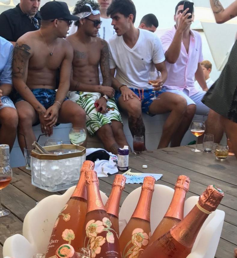 Neymar e seus parças. A champanhe de R$ 3 mil a garrafa em primeiro plano
