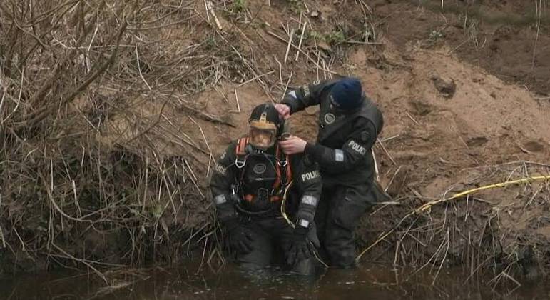 Policiais mergulham no rio após avistamento de um corpo