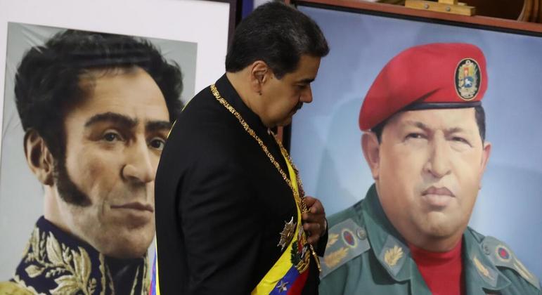 Nicolás Maduro caminha em frente aos quadros de Simón Bolívar e Hugo Chávez