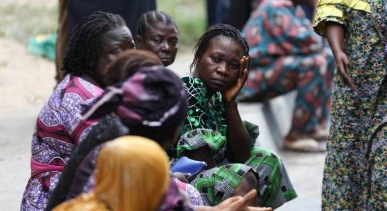 Parentes esperam enquanto equipes de resgate fazem buscas no local em que um prédio desabou em Lagos