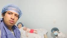 Homem com noiva de boneco de pano faz anúncio do nascimento do terceiro filho (de pano) do casal