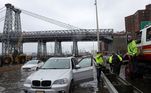 Policiais de trânsito do Departamento de Polícia de Nova York ajudam motoristas presos em uma rodovia alagada pelas fortes chuvas que atingiram a cidade na madrugada desta quinta para sexta-feira (29)