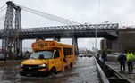 Um ônibus escolar dirige na FDR Drive, emManhattan, perto da ponte de Williamsburg; ruas ficaram alagadas por causa das fortes chuvas que atingiram a cidade de Nova York na madrugada desta quinta para sexta-feira (29)