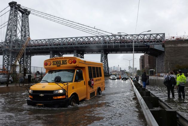 Um ônibus escolar dirige na FDR Drive, emManhattan, perto da ponte de Williamsburg; ruas ficaram alagadas por causa das fortes chuvas que atingiram a cidade de Nova York na madrugada desta quinta para sexta-feira (29)