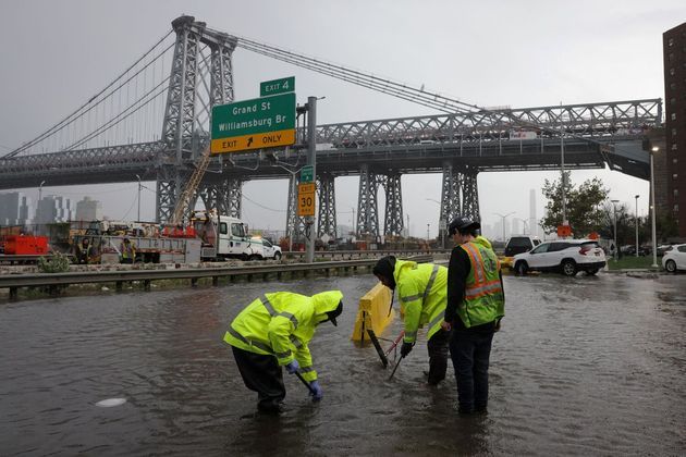 Trabalhadores do Departamento de ProteçãoAmbiental de Nova York tentam desobstruir drenos bloqueados pelas fortes chuvas que atingiram a cidade de Nova York na madrugada desta quinta para sexta-feira (29)