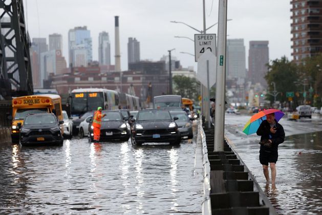 Carros ficam travados em uma rua alagada depois das forteschuvas que atingiram a cidade de Nova York na madrugada desta quinta para sexta-feira(29)