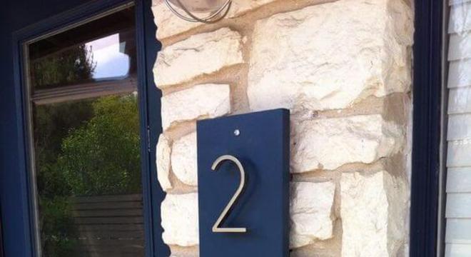 Número de casa com placa azul e números em inox