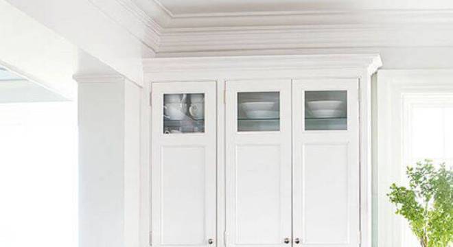 O armário de cozinha de madeira escura com tampo de granito branco encanta a decoração