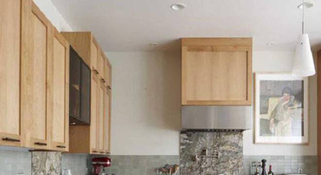 O armário de madeira se harmoniza com utensílios metálicos