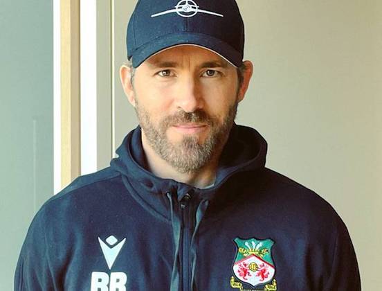  O ator canadense Ryan Reynolds, o Deadpool, 45 anos, é dono do Wrexham, do País de Gales, da quinta divisão inglesa. Em 2020, ele comprou o clube junto com o ator Rob McElhenney.