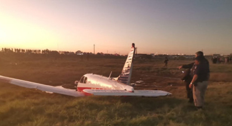 O avião acidentado, já protegido por policiais