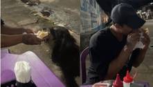 Homem viraliza ao dividir lanche com cachorro de rua