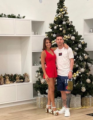 O craque argentino Messi, que este ano foi para o PSG, posa com bermuda número 10, ao lado da mulher Antonela Roccuzzo, Desta vez, o Natal é em Paris. A árvore e o lindo presépio são em cores discretas para não ofuscar o vestido, claro.