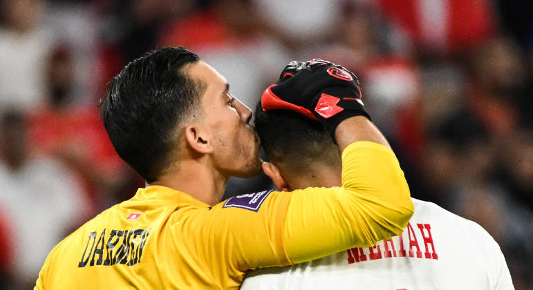 O goleiro Aymen Dahmen dá um beijinho na cabeça do zagueiro Yassine Meriah na partida entre Tunísia e Dinamarca