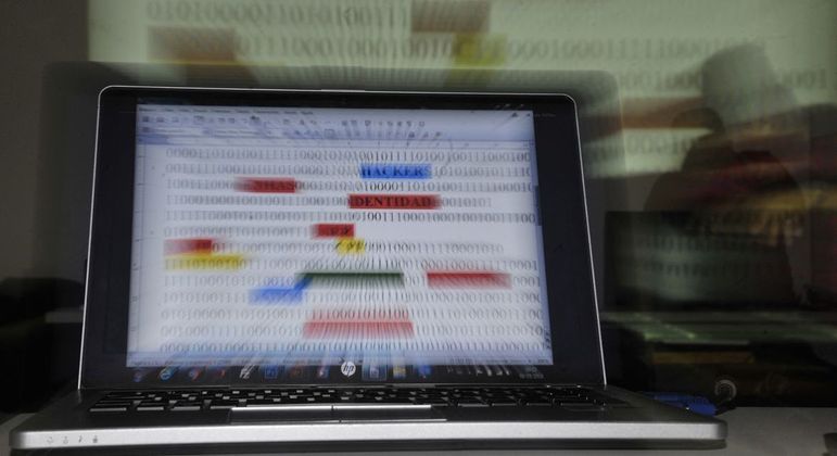 Computador aberto com códigos binários na tela