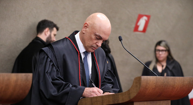 O ministro Alexandre de Moraes assinando o termo de posse como presidente do TSE