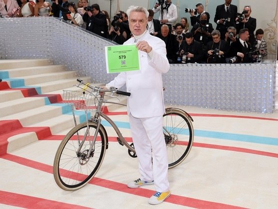 O músico David Byrne chega de bike ao evento que é considerado o "Oscar da Moda"