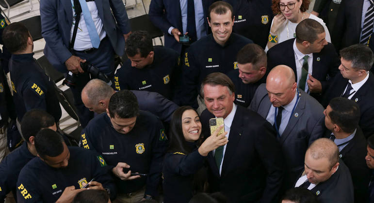 O presidente Jair Bolsonaro cercado de agentes da Polícia Rodoviária Federal