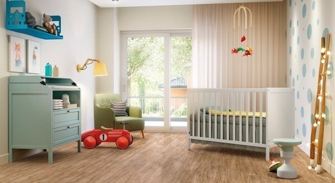 O quarto de bebê recebeu acabamento com piso laminado