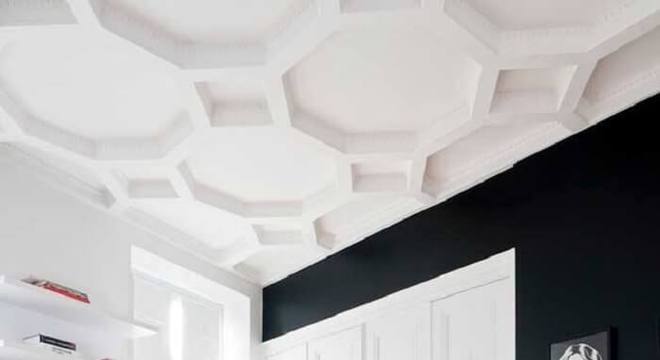 O teto feito com placa de gesso 3D se contrasta com as paredes em tom preto