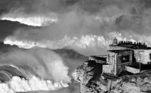 As gigantes ondas de Nazaré, em Portugal, são uma atração para os humanos e recebem muitas pessoas para apreciá-las. Apesar de não ter vencido, a foto do finalista João Pompeu com certeza mostra os dois mundos. 'O momento de três ondas gigantes quebrando com uma luz perfeita durou menos de um minuto, mas valeu todo o esforço', conta o fotógrafo