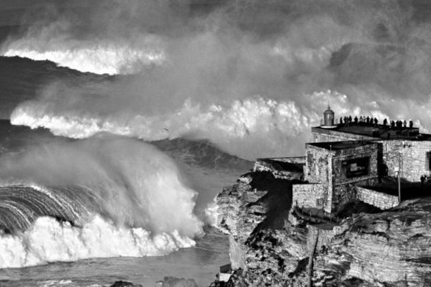 As gigantes ondas de Nazaré, em Portugal, são uma atração para os humanos e recebem muitas pessoas para apreciá-las. Apesar de não ter vencido, a foto do finalista João Pompeu com certeza mostra os dois mundos. 