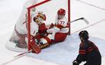 No jogo entre China e Canadá pelas quartas de final do Hockey no Gelo, dois jogadores chineses pararam dentro do gol em um ataque canadense