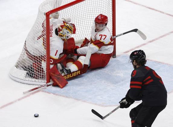 Durante o jogo entre China e Canadá pelas quartas de final do Hockey no Gelo, dois jogadores chineses pararam dentro do gol durante um ataque canadense Durante o jogo entre China e Canadá pelas quartas de final do Hockey no Gelo, dois jogadores chineses pararam dentro do gol durante um ataque canadense