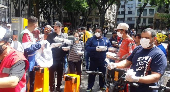 Voluntários da ONG Novos Sonhos entregam marmitas a moradores de rua do centro de São Paulo